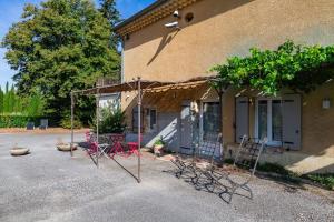 a house with tables and chairs in front of it at L'ormeau in Charols