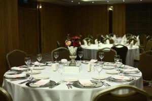 a round table with white table cloth and a vase with flowers at Ramada By Wyndham Bursa Cekirge Thermal & Spa in Bursa +71 photos
