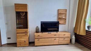 a living room with a tv on a wooden dresser at Hotel Restaurant Zur Eisernen Hand in Viersen
