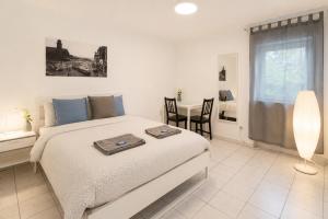 a bedroom with a bed and a table with chairs at Kirchberg Comfort Rooms in Luxembourg