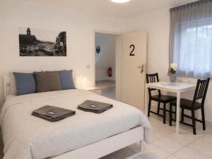 a bedroom with a bed and a table with a chair at Kirchberg Comfort Rooms in Luxembourg