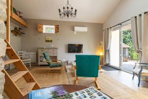 a living room with a chandelier and a table and chairs at L'ormeau in Charols +29 photos