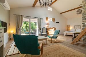 a living room with a couch and a table and chairs at L'ormeau in Charols