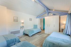 a bedroom with two beds in a room with blue at Gite de l'Ocean in Genouillé +25 photos