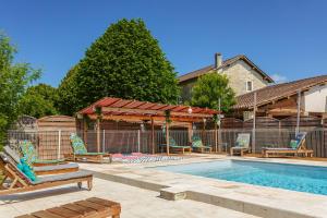 a swimming pool with chairs next to a house at Gite de l'Ocean in Genouillé