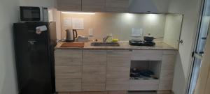 a kitchen with a black refrigerator and a person sitting in the drawer at Entre Verde in Concepción del Uruguay