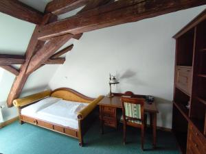 a bedroom with a wooden bed and a desk at Depandance Vodoléčba in Lázně Libverda