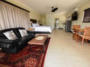 a living room with a couch and a bed at Driftwood on 10 La Lucia in Durban