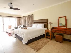 a bedroom with a bed and a mirror and a piano at Driftwood on 10 La Lucia in Durban +28 photos