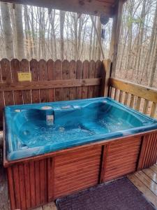 a jacuzzi tub with a wooden fence at Thunder Ridge Cabins B&B - Otter Lodge in Rockbridge