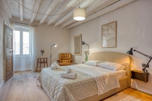 a bedroom with a large bed and a chair at Mediterraneo Seaview Apartments in Rovinj