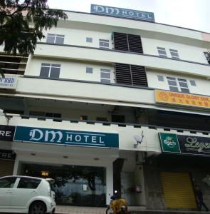 DM Hotel في كوتا كينابالو: مبنى متوقف امامه سيارة