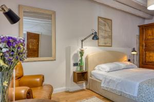 a bedroom with a bed and a chair and a mirror at Mediterraneo Seaview Apartments in Rovinj +82 photos