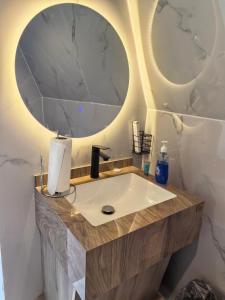 a bathroom with a sink and a mirror at شاليهات سكوْن in Al Baha