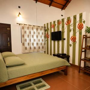 a bedroom with a bed and a television in it at Fiddlehead Fern in Kurchi