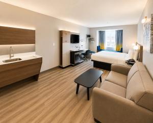 a hotel room with a bed and a couch at Microtel Inn & Suites by Wyndham Macon in Wesleyan Hills