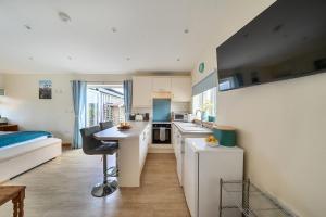 a kitchen with white cabinets and a table in a room at Ashclose Lodge Annexe in Sherborne +27 photos