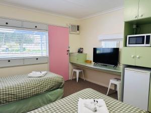a room with two beds and a desk with a computer at Stonez Boutique Accommodation in Clunes