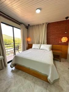 a bedroom with a large bed and a large window at Altura525 hotel in Jarabacoa