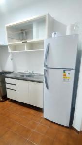 a white refrigerator in a kitchen with a sink at Olivos Lujan in Luján