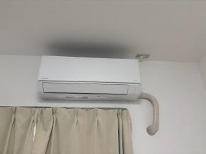 a television hanging from a wall with a curtain at 板橋 RCアネックス Rc202 in Tokyo