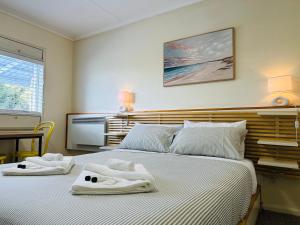 a bedroom with two beds with towels on them at Stonez Boutique Accommodation in Clunes
