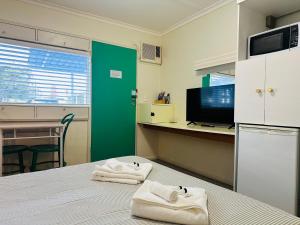 a room with a bed with towels on it at Stonez Boutique Accommodation in Clunes