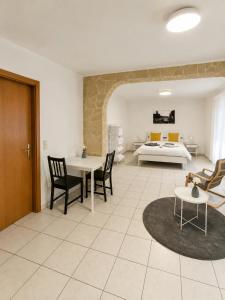 a living room with a table and chairs and a bed at Kirchberg Comfort Rooms in Luxembourg