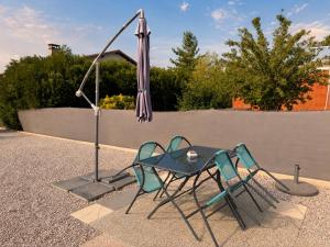 a table and two chairs and an umbrella at Maison avec piscine in Golbey