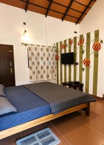 a bedroom with a large bed and a television at Fiddlehead Fern in Kurchi