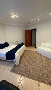 a bedroom with two beds and a rug at Chácara com Piscina, Hidro, Campo de futebol, Beach Tennis, Sinuca e Churrasqueira in Analândia +26 photos