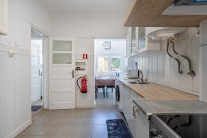 a kitchen with white cabinets and a red fire extinguisher at AL Fancy Discoveries in Lisbon