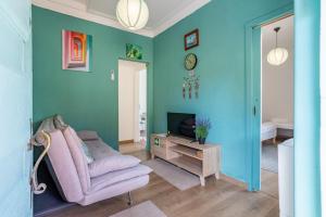 a living room with a pink chair and a tv at AL Fancy Discoveries in Lisbon