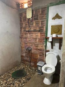 a bathroom with a toilet and a stone wall at Highway 20 Homestay in Phong Nha +55 photos