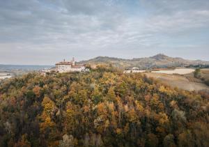a house on top of a hill with trees at BORGO MONCHIERO HERITAGE by Atmosphere in Monchiero