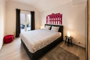 a bedroom with a large bed with a red headboard at Les Suites de Nanesse in Liège
