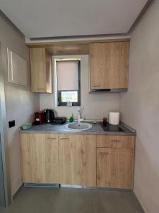 a kitchen with wooden cabinets and a sink at Villa Eden in Kallithea Halkidikis