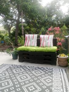 a green couch with two pillows on a patio at Kaye Daisy in Vieux Fort