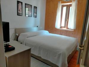 a bedroom with a white bed and a window at La Quiete in Ponte Caffaro