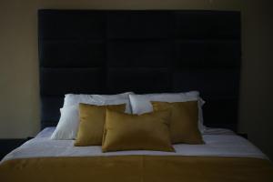 a bed with yellow pillows and a black headboard at Isimi haven in Lekki