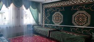 a room with a bed with a green wall and a window at STALBEK Guest House in Kochkorka