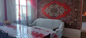 a room with a table and a chair and a rug at STALBEK Guest House in Kochkorka