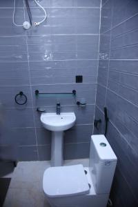a bathroom with a white toilet and a sink at Isimi haven in Lekki