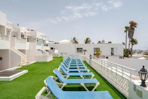 a row of blue lounge chairs on the balcony of a hotel at Vittorio Fabulous View in Tías