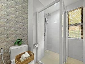 a bathroom with a shower and a toilet and a shower at El Jardin Residences in Panglao Island