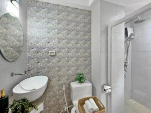 a bathroom with a toilet and a sink and a mirror at El Jardin Residences in Panglao Island