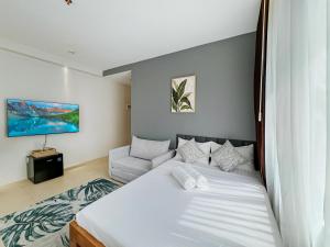 a bedroom with a large bed and a couch at El Jardin Residences in Panglao Island +70 photos