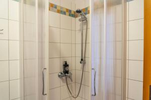 a shower with a shower curtain in a bathroom at Nidum - Šariš Park Hotel & Wellness in Prešov
