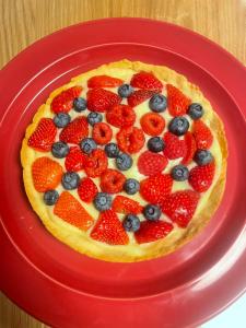 a pie with strawberries and blueberries on a red plate at Al Vicolo in Telve