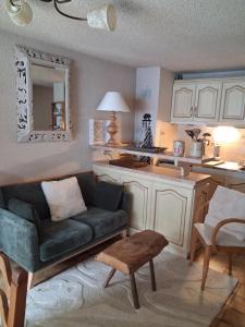 a living room with a couch and a kitchen at Hameau des Granges in Bourisp